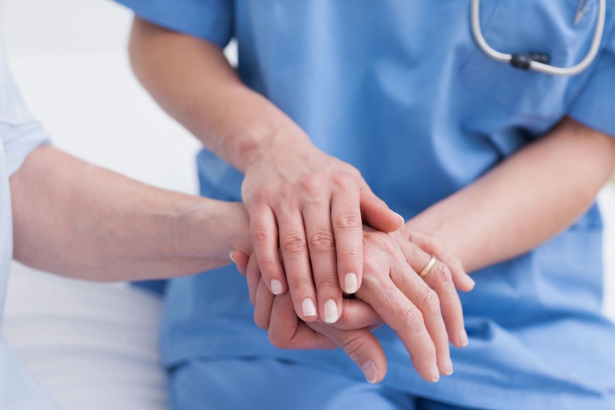Nurse holding patients hand