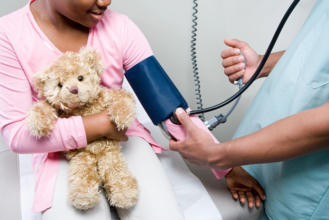 Nurse taking blood pressure of woman