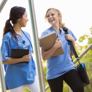 two nurses laughing together in the hall